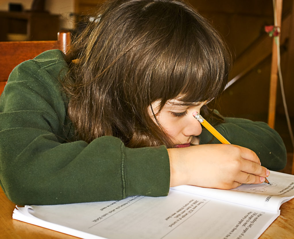 Child with ADHD symptoms & treatment working on homework