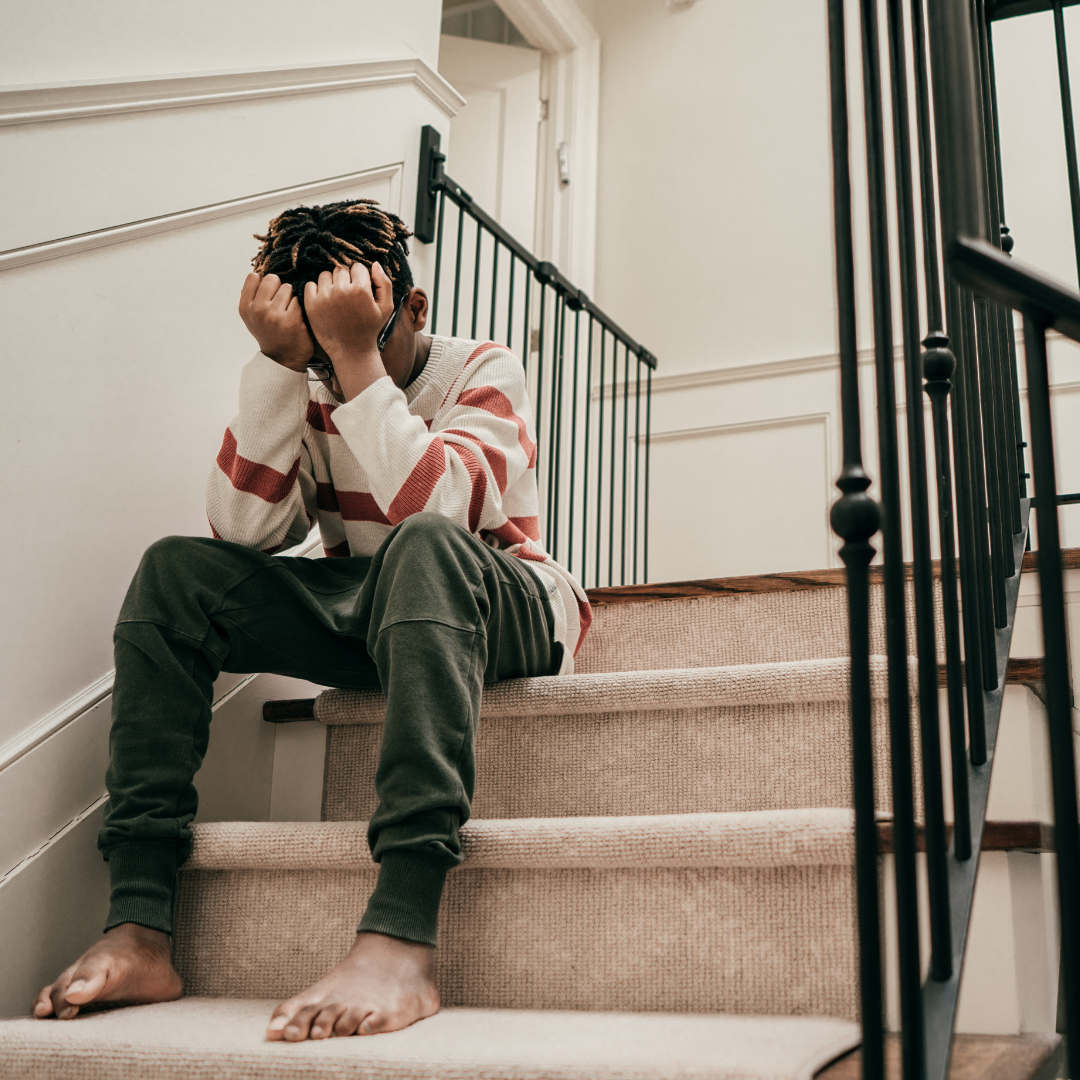 boy holding head in hands